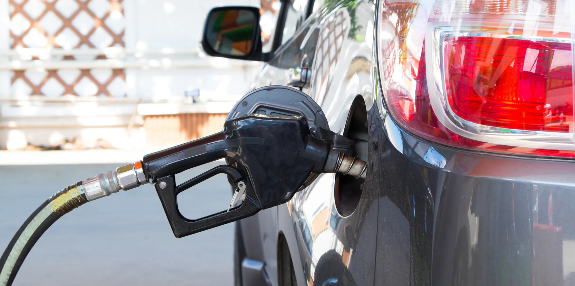 A fuel pump is positioned filling up a car with fuel