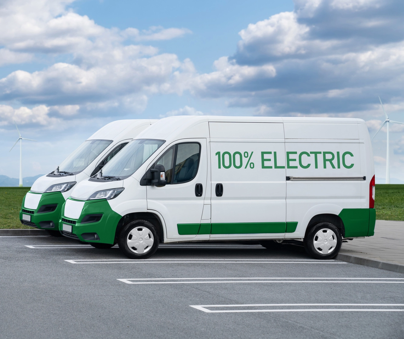 Two white electric vans with 100% electric written on the side of van
