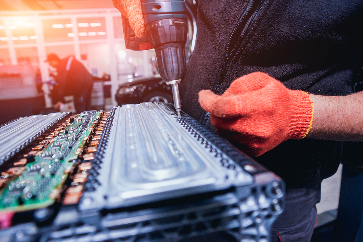 EV battery with technician hands shown to right of image